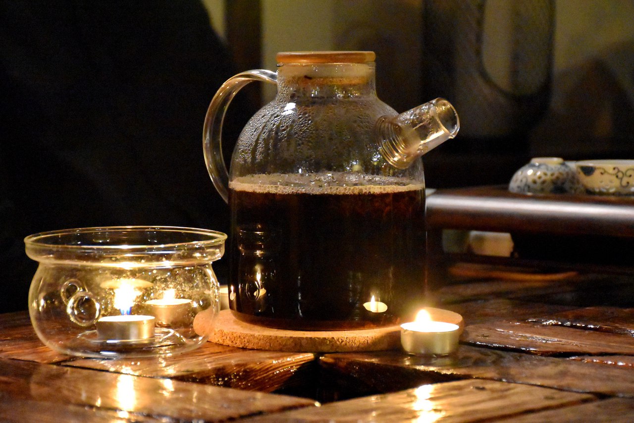 Густой настой шу пуэра в стеклянном чайнике на подогреве